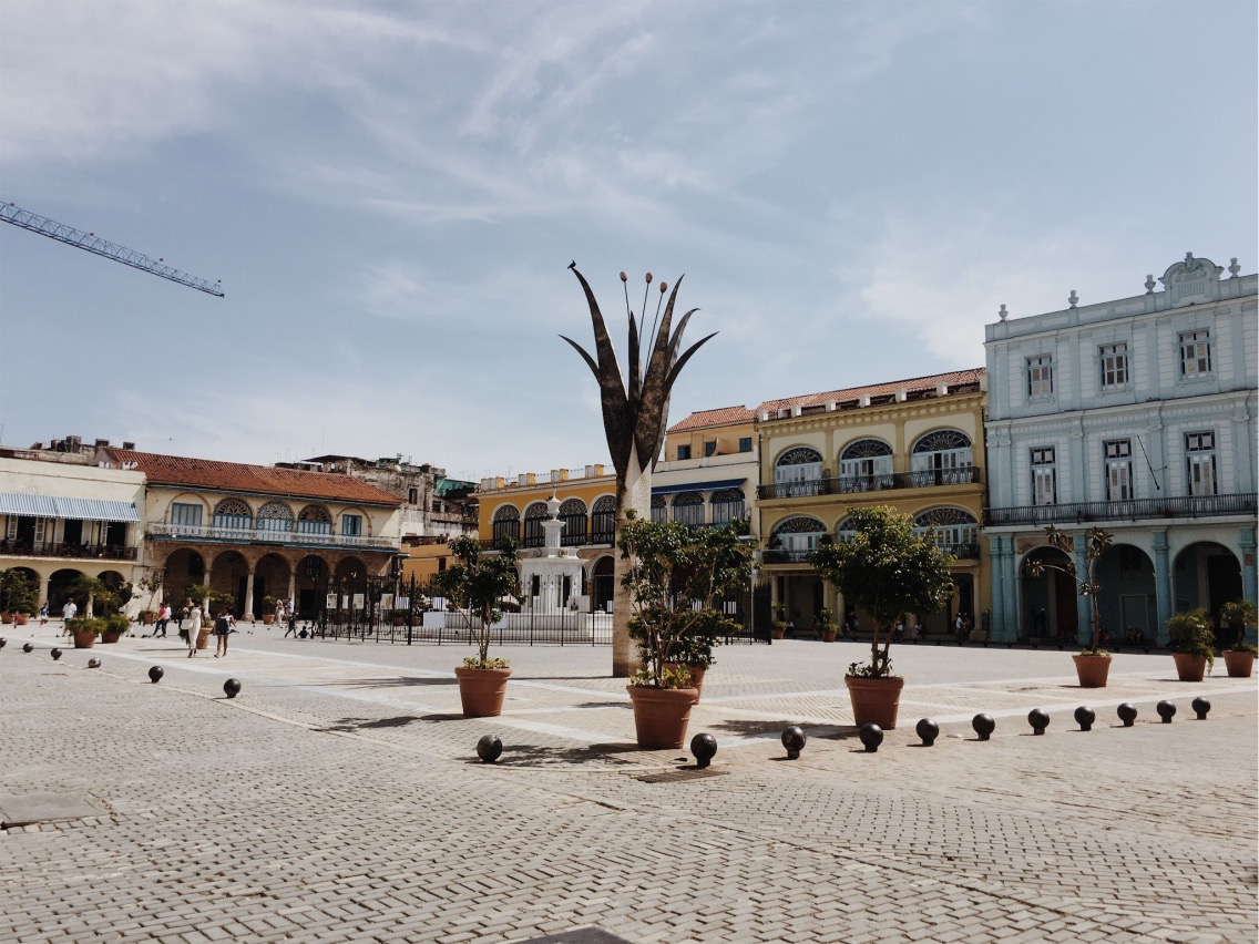 Exploring Havana Vieja and admiring a plaza's architecture.
