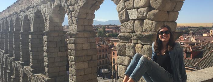 Katherine seated beside the Roman aqueducts on a day trip with the program to Segovia.